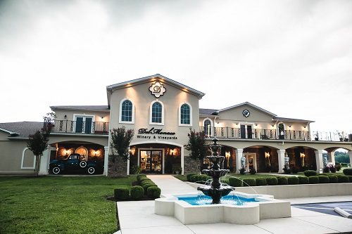 A house with a fountain in front of it, perfect for hosting a wine tour.