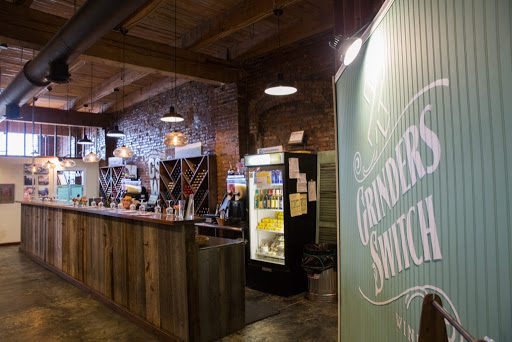 A rustic bar with a wooden counter and a charming wooden sign.