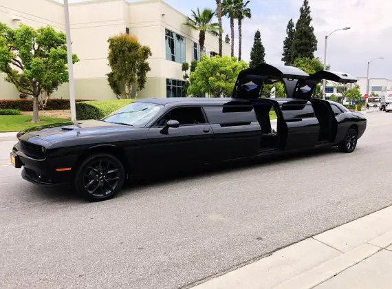 A black stretch limo is parked on the side of the road.