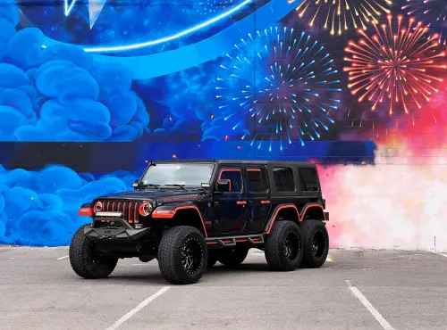 A jeep, used for transportation service, parked in front of a firework painting.