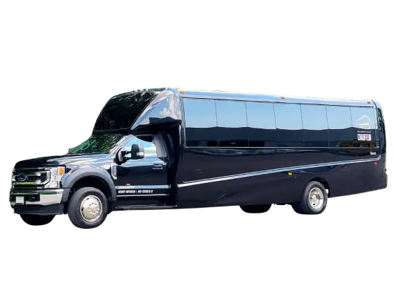 A black party bus parked in front of a black background.