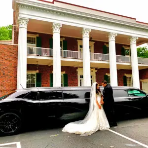 A black dodge limousine is parked in front of a marriage hall