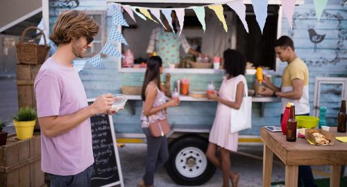 A group of people standing near a food truck.