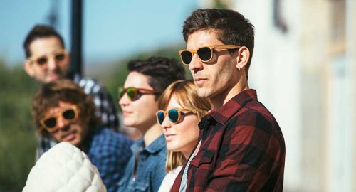 A group of people wearing sunglasses on the street.